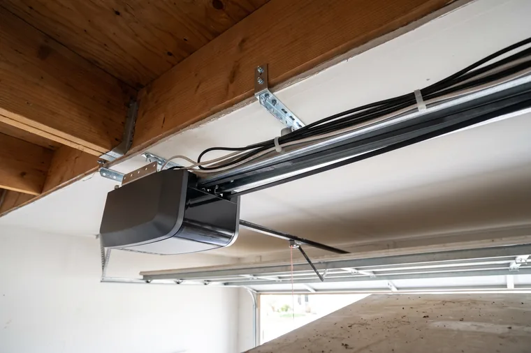 A new belt-drive garage door opener installed on a garage ceiling with a taut belt and tidy wiring