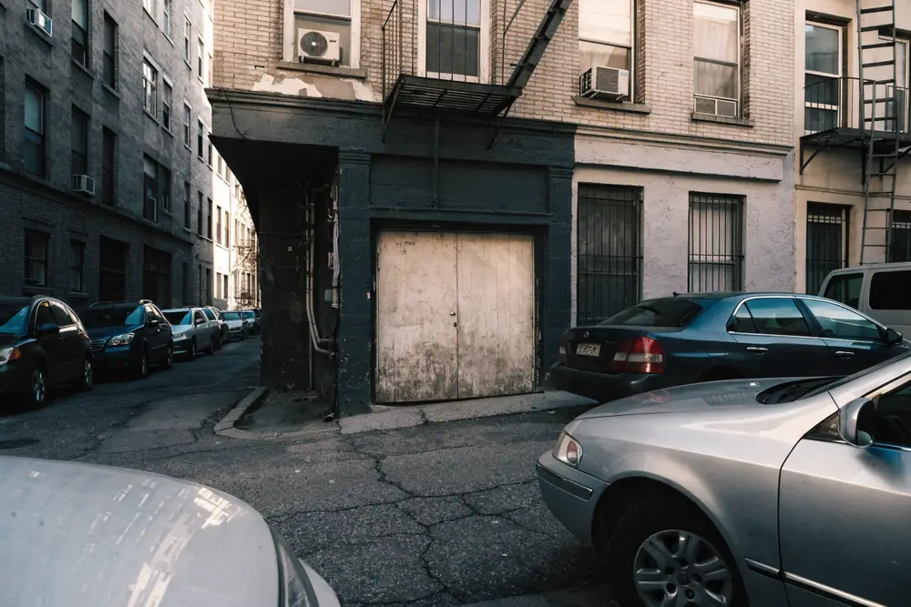 A narrow ground-floor garage bay under a multifamily row home, typical of Union City's density