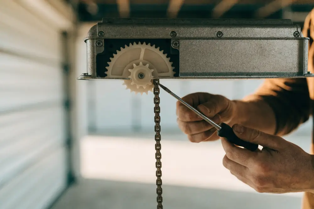 A technician exposing the drive gear and chain sprocket on an opener