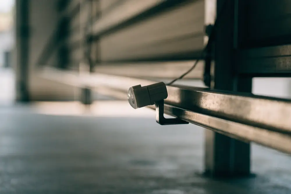 A garage door safety sensor mounted low on the door track